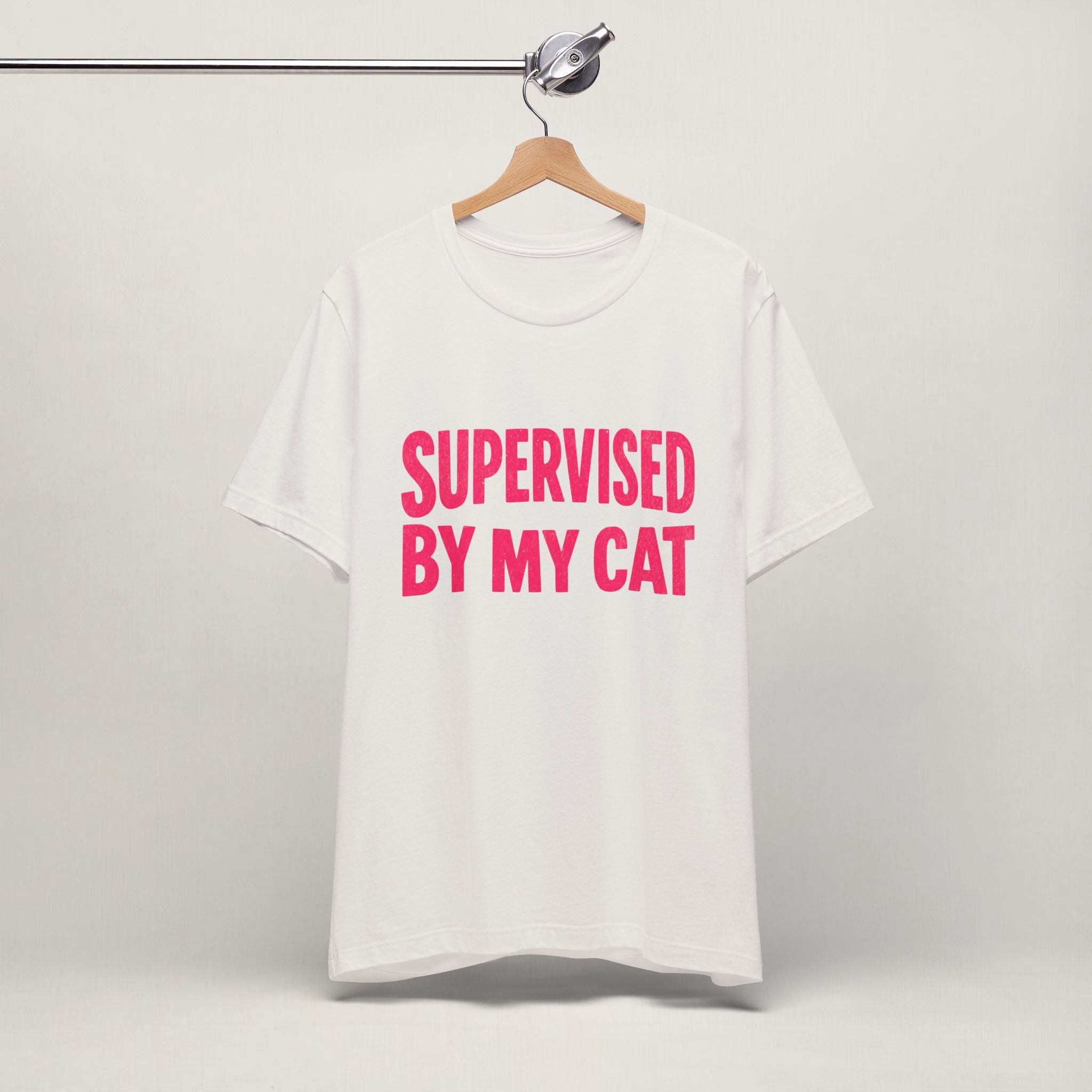 Vintage white Supervised By My Cat t-shirt with pink graphic hanging on display