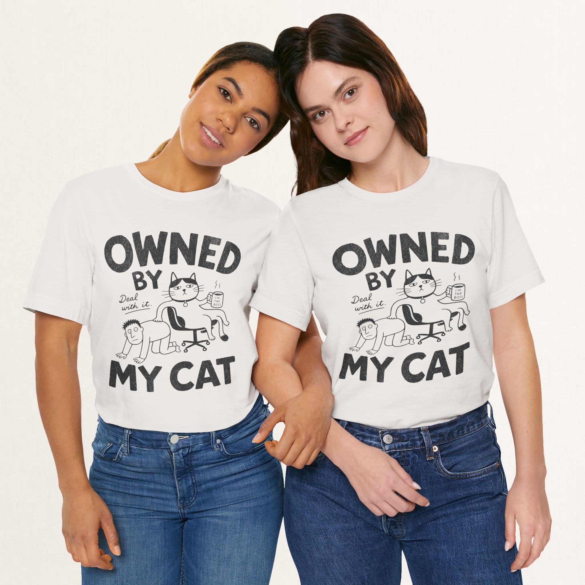 Two women wearing vintage white Owned By My Cat t-shirts with comic cat boss illustration