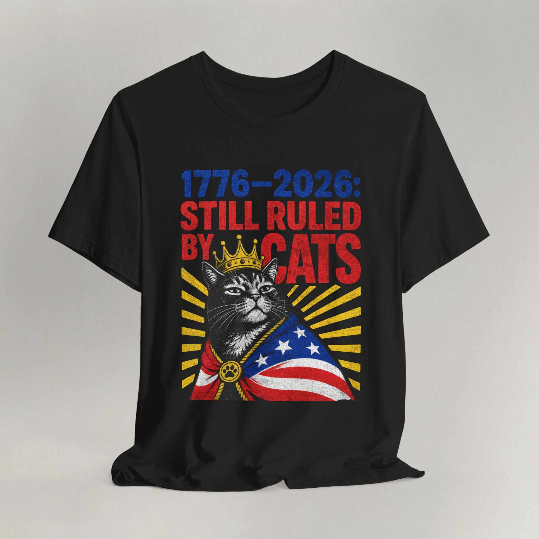 Flat lay of black graphic cat t-shirt with Still Ruled By Cats patriotic design