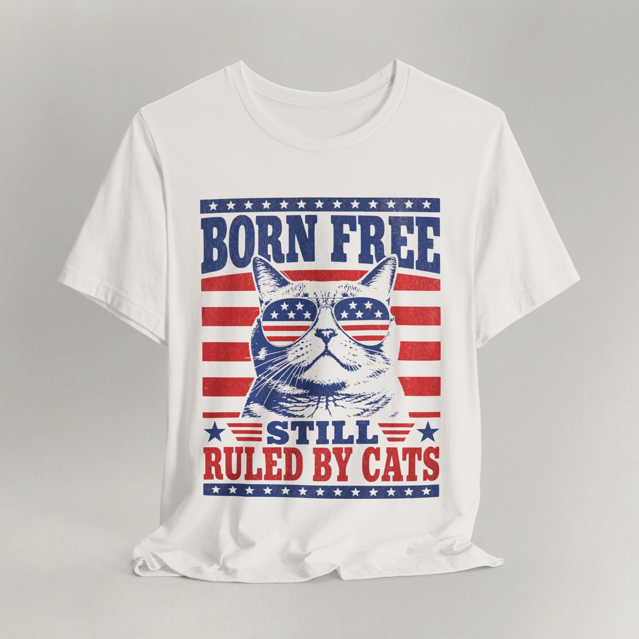 Flat lay of vintage white patriotic cat t-shirt with Born Free Still Ruled By Cats print design