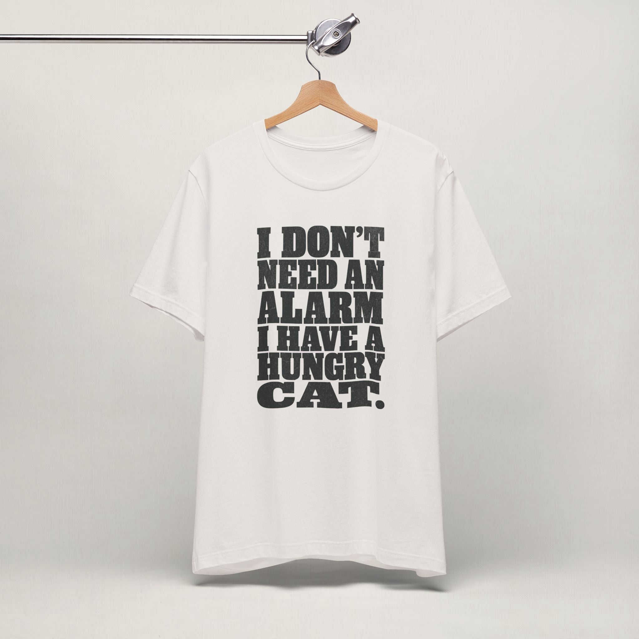 Vintage white I Don't Need An Alarm cat t-shirt on a hanger