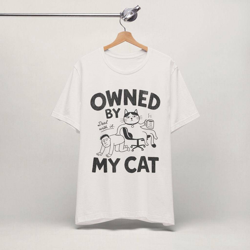 Vintage white Owned By My Cat t-shirt with comic graphic hanging on display