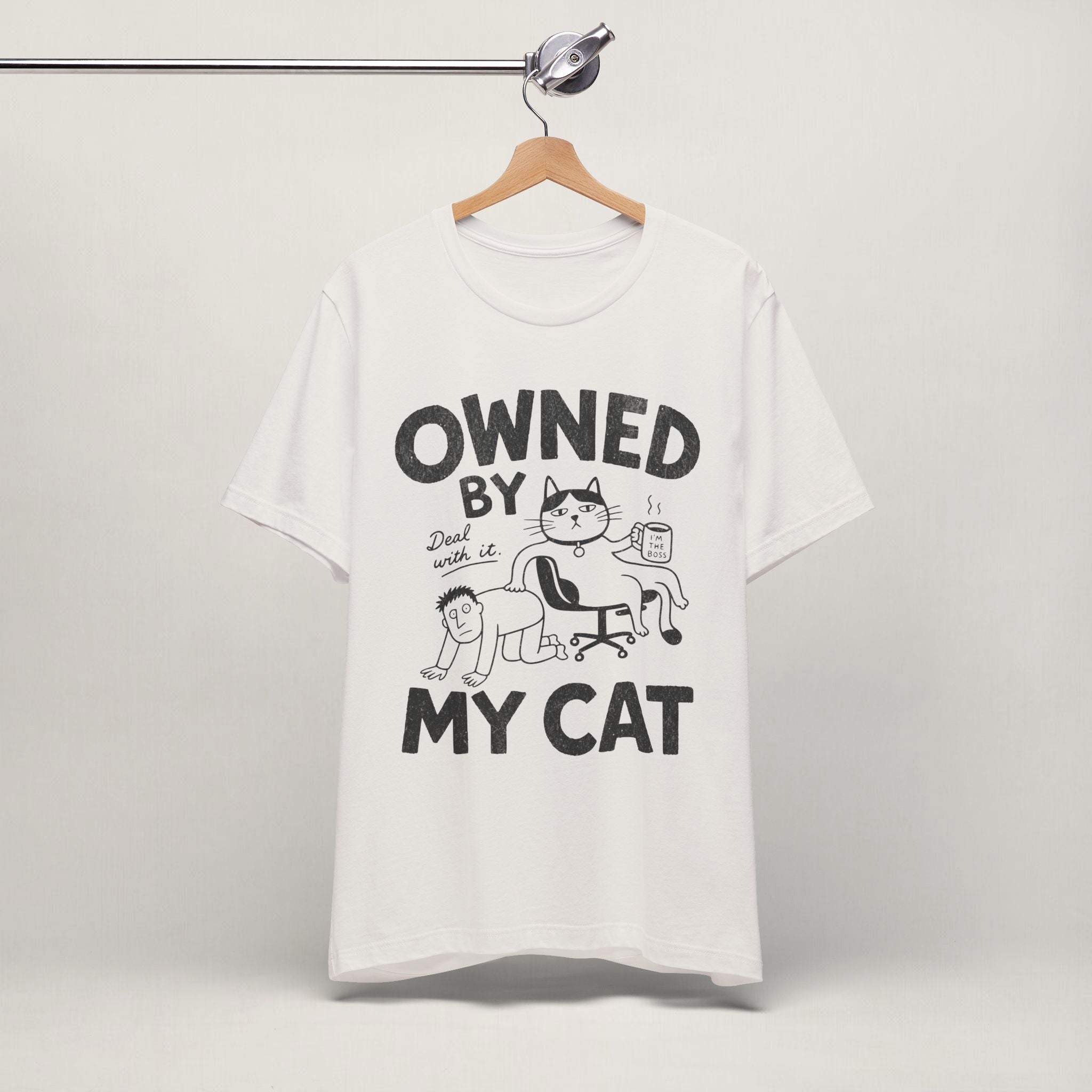 Vintage white Owned By My Cat t-shirt with comic graphic hanging on display