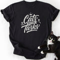 Black Cats Before Tasks graphic tee featuring cursive text and paw prints