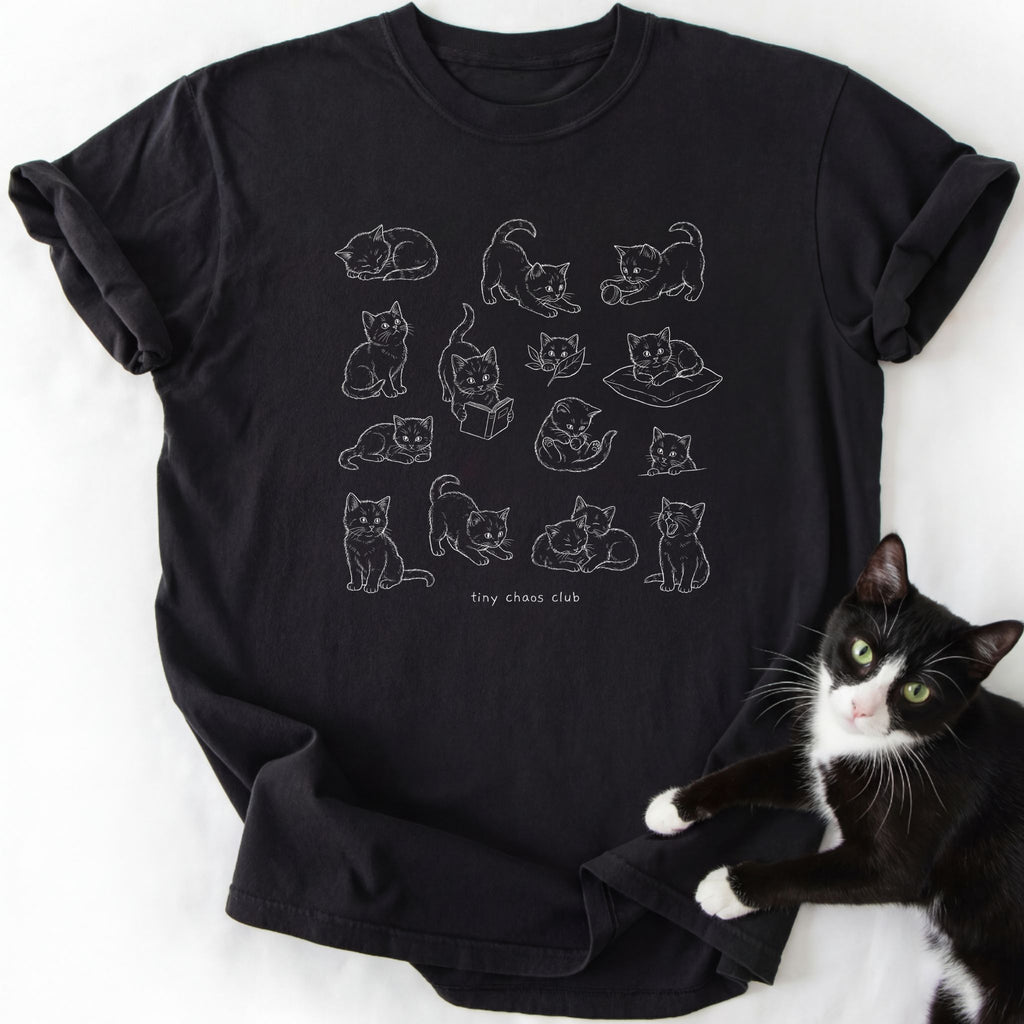 Tiny Chaos Club Kittens graphic tee in black with white line-art kitten grid design