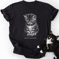 Black crew-neck t-shirt featuring black-and-white tabby kitten illustration and 'I'm Just Listening' slogan