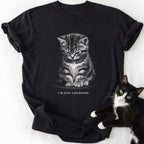 Black crew-neck t-shirt featuring black-and-white tabby kitten illustration and 'I'm Just Listening' slogan