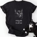 Black Feed or Fear Me cat graphic tee with grayscale cat illustration and text