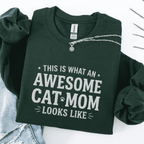 Forest Green awesome cat mom embroidered sweatshirt with “This Is What An Awesome Cat Mom Looks Like” text, folded flat on light denim