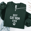 Forest Green best cat mom ever embroidered sweatshirt with paw print detail, folded flat on light denim