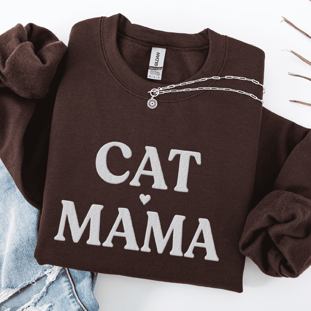 Dark Chocolate cat mama embroidered sweatshirt, folded flat on light denim