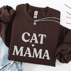 Dark Chocolate cat mama embroidered sweatshirt, folded flat on light denim