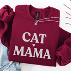 Maroon cat mama embroidered sweatshirt, folded flat on light denim