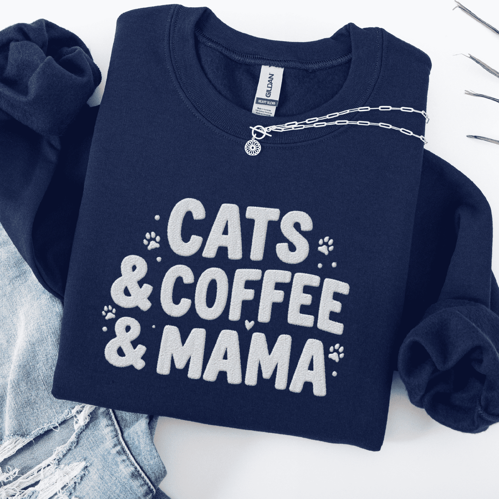 Navy cats coffee mama embroidered sweatshirt with paw print detail, folded flat on light denim
