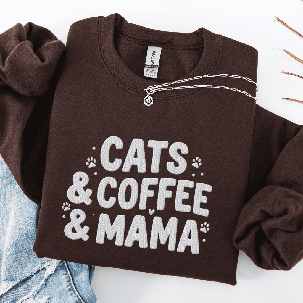 Dark Chocolate cats coffee mama embroidered sweatshirt with paw print detail, folded flat on light denim