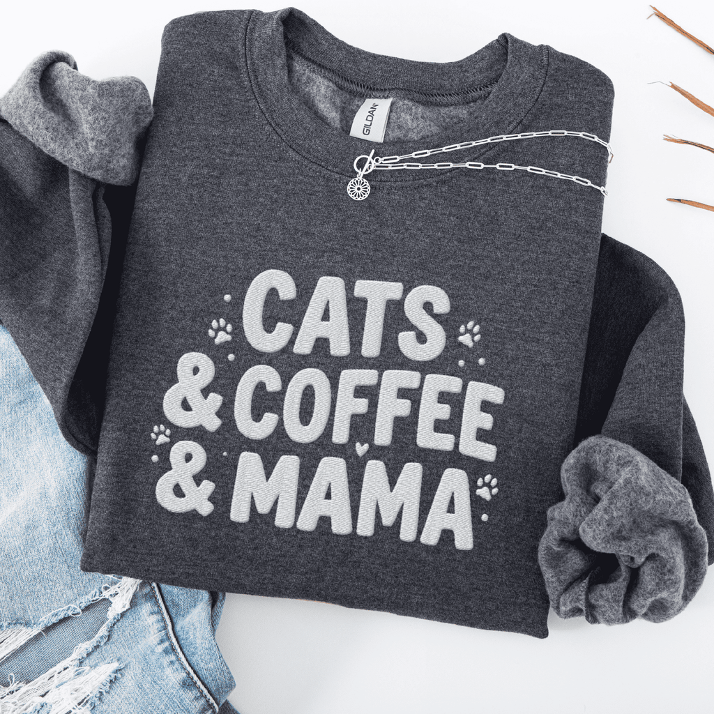 Dark Heather cats coffee mama embroidered sweatshirt with paw print detail, folded flat on light denim