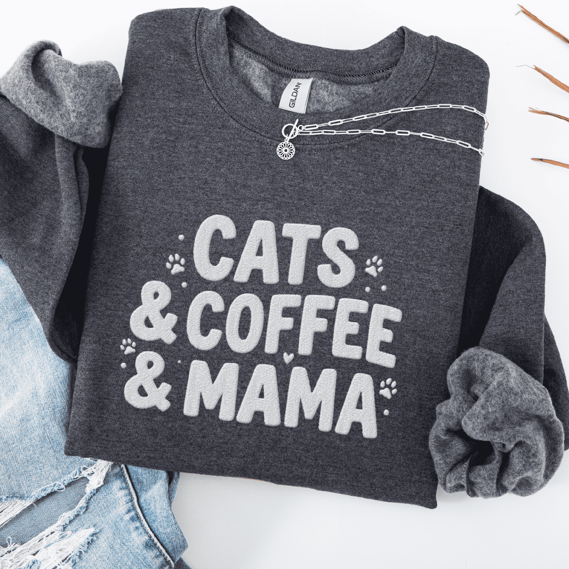 Dark Heather cats coffee mama embroidered sweatshirt with paw print detail, folded flat on light denim