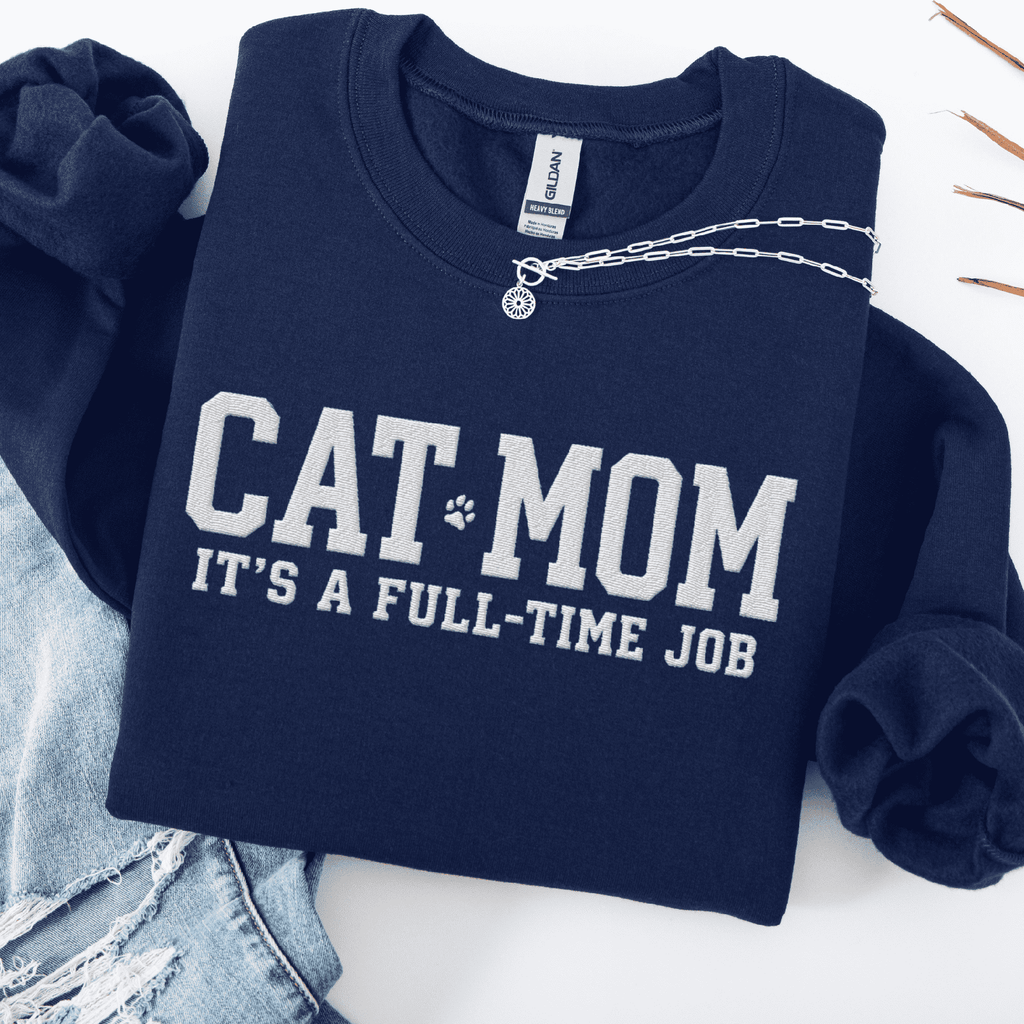 Navy cat mom embroidered sweatshirt with “Cat Mom It’s A Full-Time Job” text, folded flat on light denim