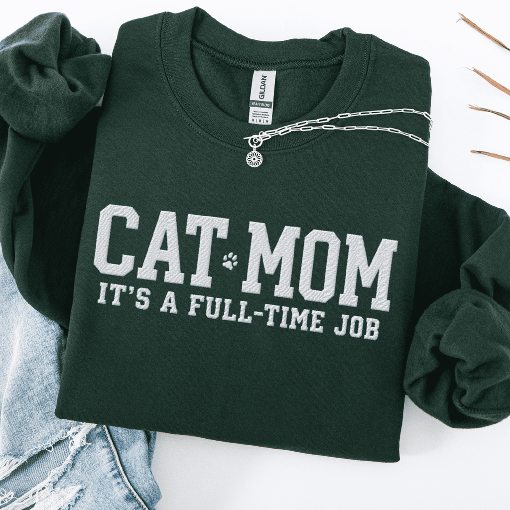 Forest Green cat mom embroidered sweatshirt with “Cat Mom It’s A Full-Time Job” text, folded flat on light denim