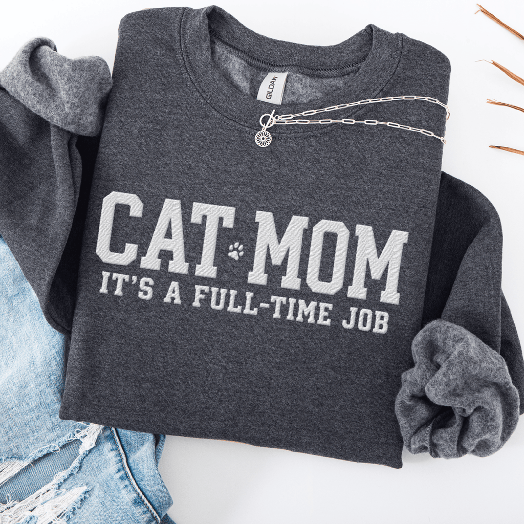 Dark Heather cat mom embroidered sweatshirt with “Cat Mom It’s A Full-Time Job” text, folded flat on light denim
