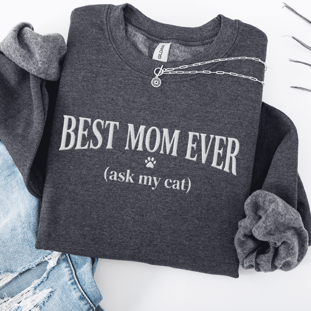 Dark Heather cat mom embroidered sweatshirt with “Best Mom Ever (ask my cat)” text, folded flat on light denim