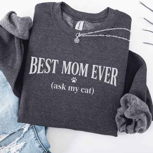 Dark Heather cat mom embroidered sweatshirt with “Best Mom Ever (ask my cat)” text, folded flat on light denim