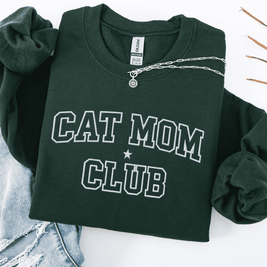 Forest Green cat mom club embroidered sweatshirt, folded flat on light denim