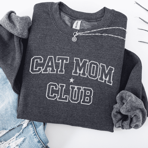 Dark Heather cat mom club embroidered sweatshirt, folded flat on light denim