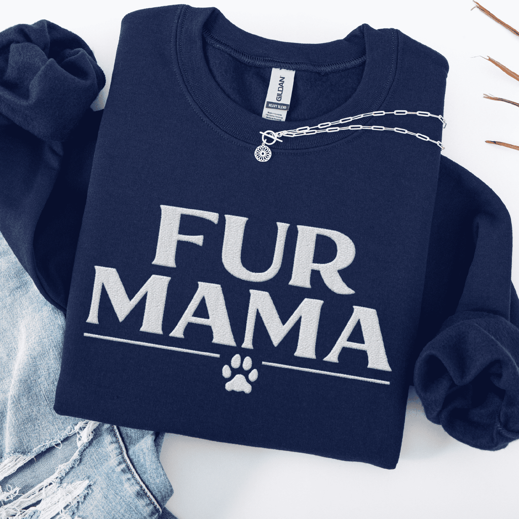 Navy fur mama embroidered sweatshirt with paw print detail, folded flat on light denim