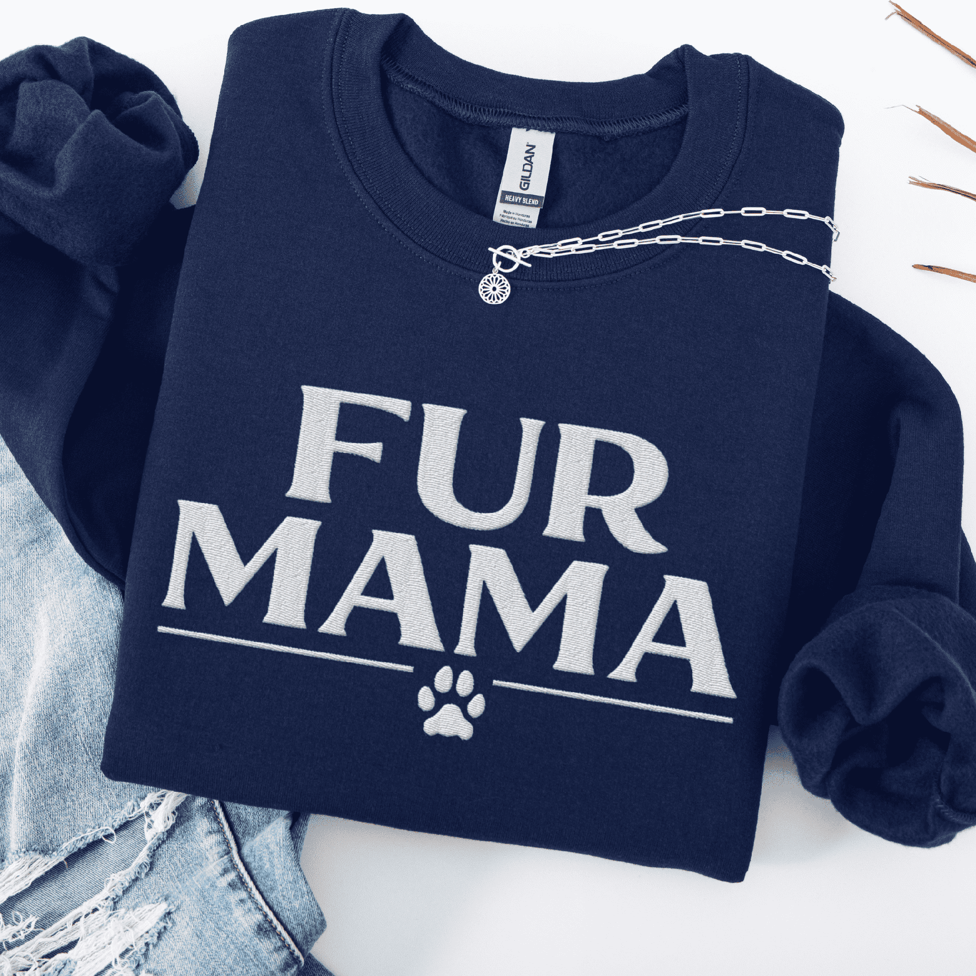 Navy fur mama embroidered sweatshirt with paw print detail, folded flat on light denim