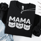 Black mama embroidered sweatshirt with cat face design, folded flat on light denim