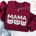 Maroon mama embroidered sweatshirt with cat face design, folded flat on light denim