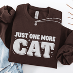 Dark Chocolate one more cat embroidered sweatshirt with “Just One More Cat” text, folded flat on light denim