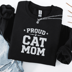 Black proud cat mom embroidered sweatshirt with “Proud Cat Mom” text, folded flat on light denim