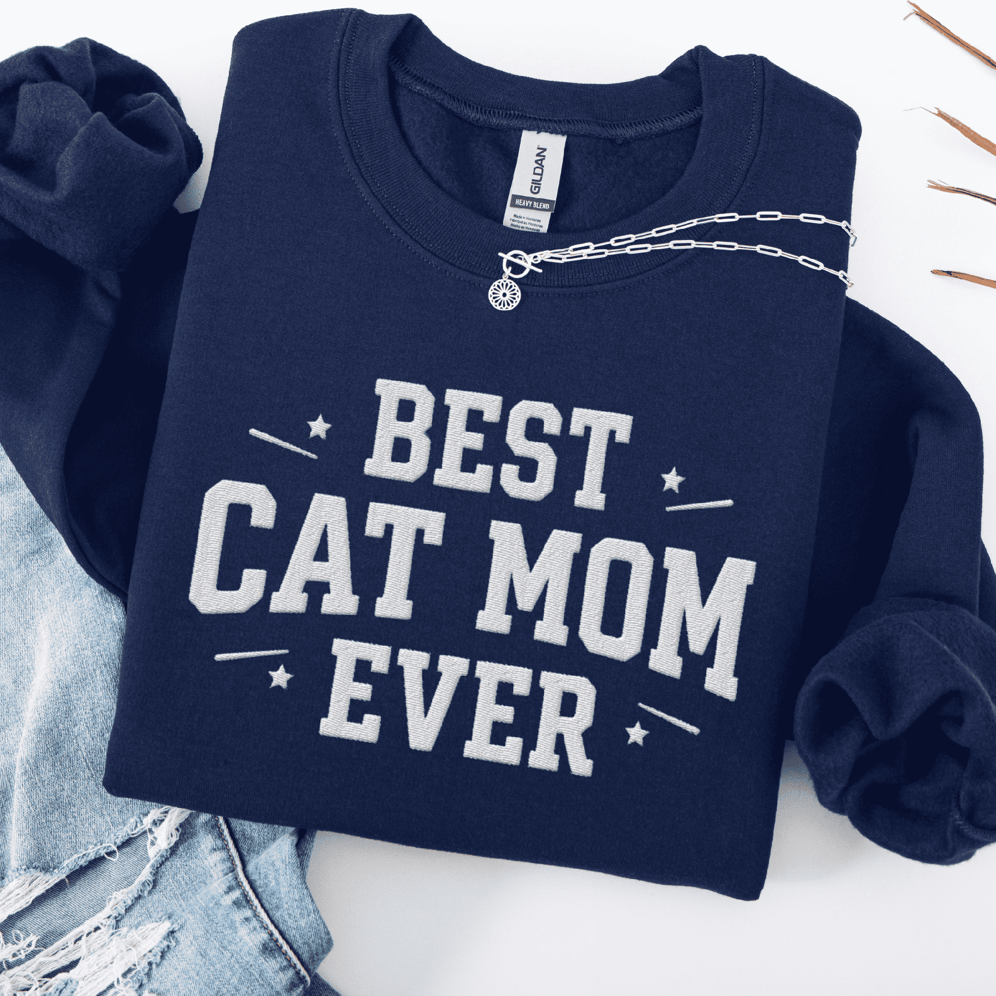 Navy cat mom embroidered sweatshirt with “Best Cat Mom Ever” text, styled flat on light denim