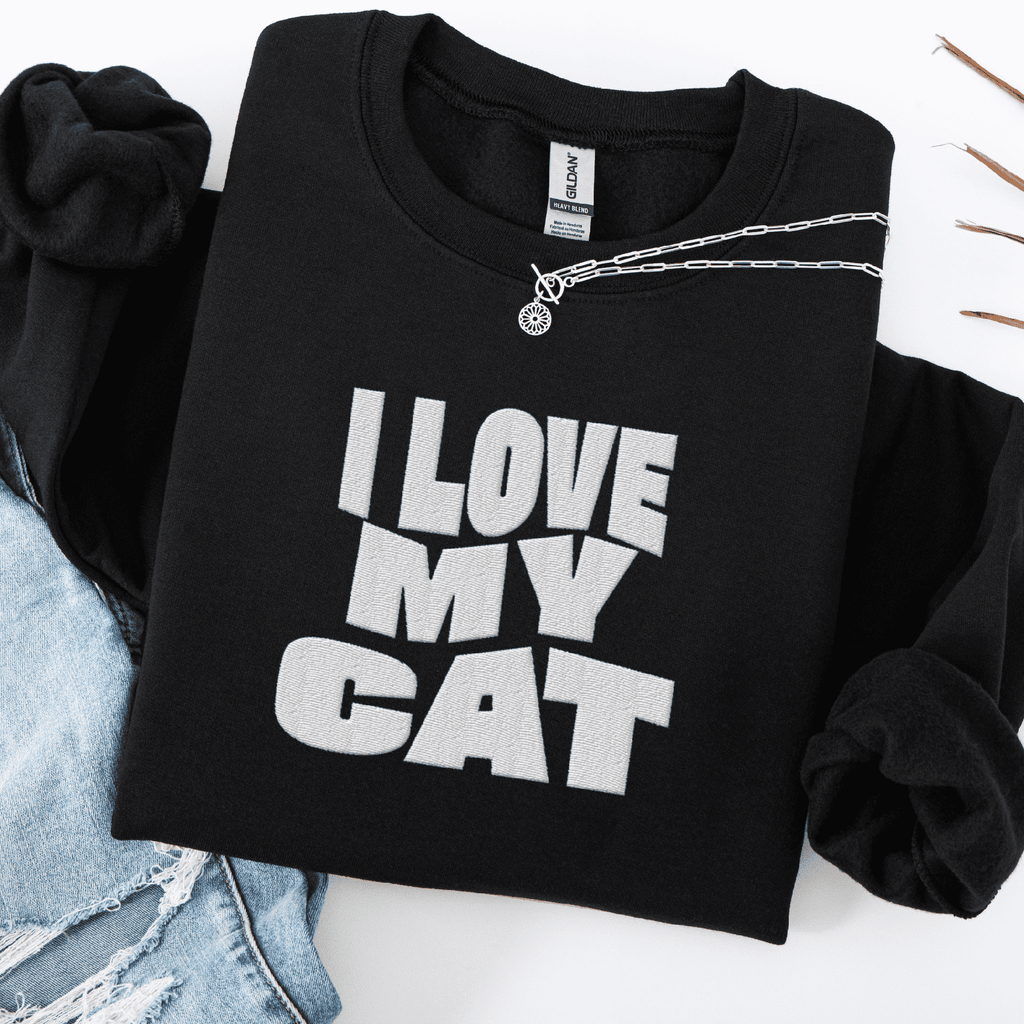 Black embroidered cat sweatshirt with the phrase “I Love My Cat” shown folded flat