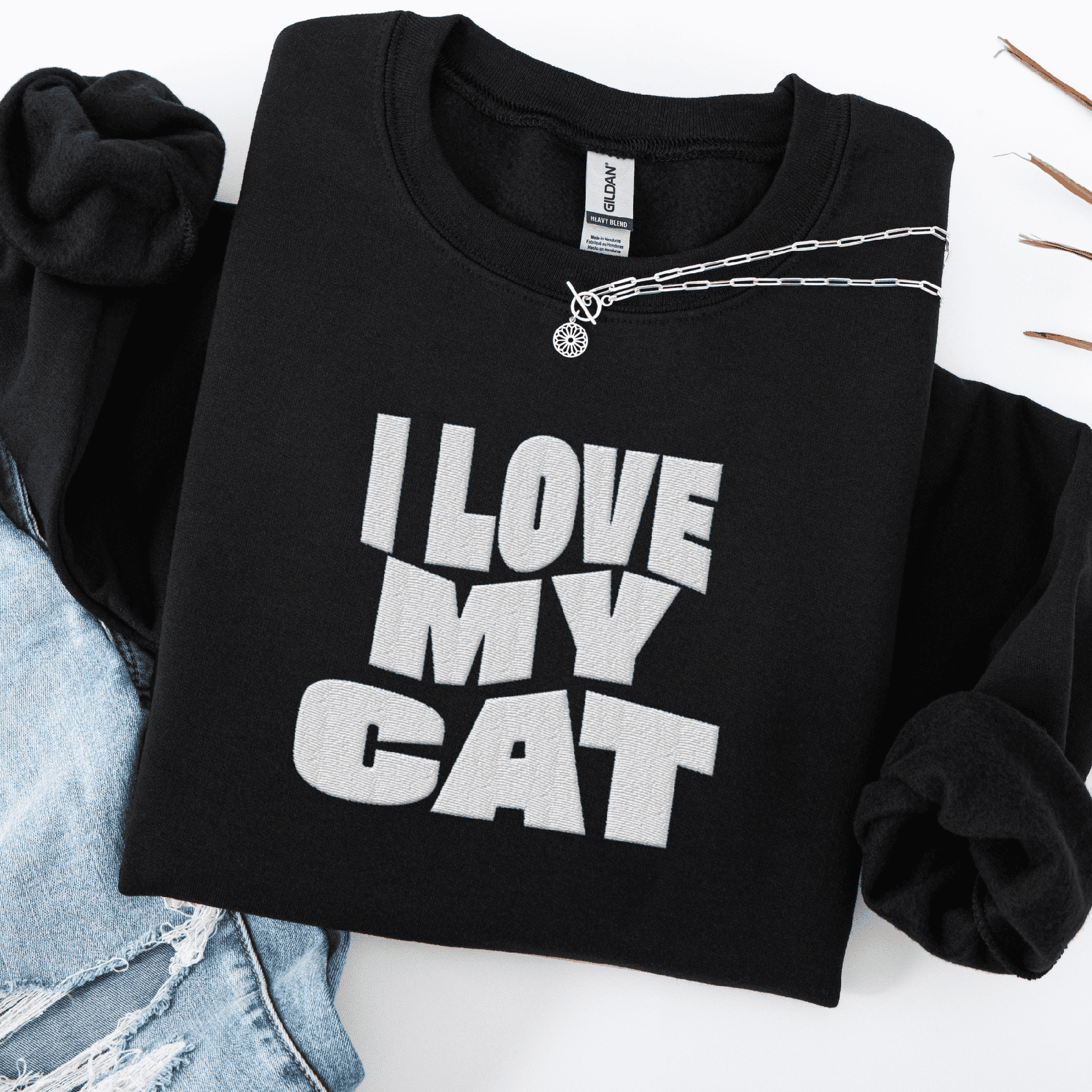 Black embroidered cat sweatshirt with the phrase “I Love My Cat” shown folded flat