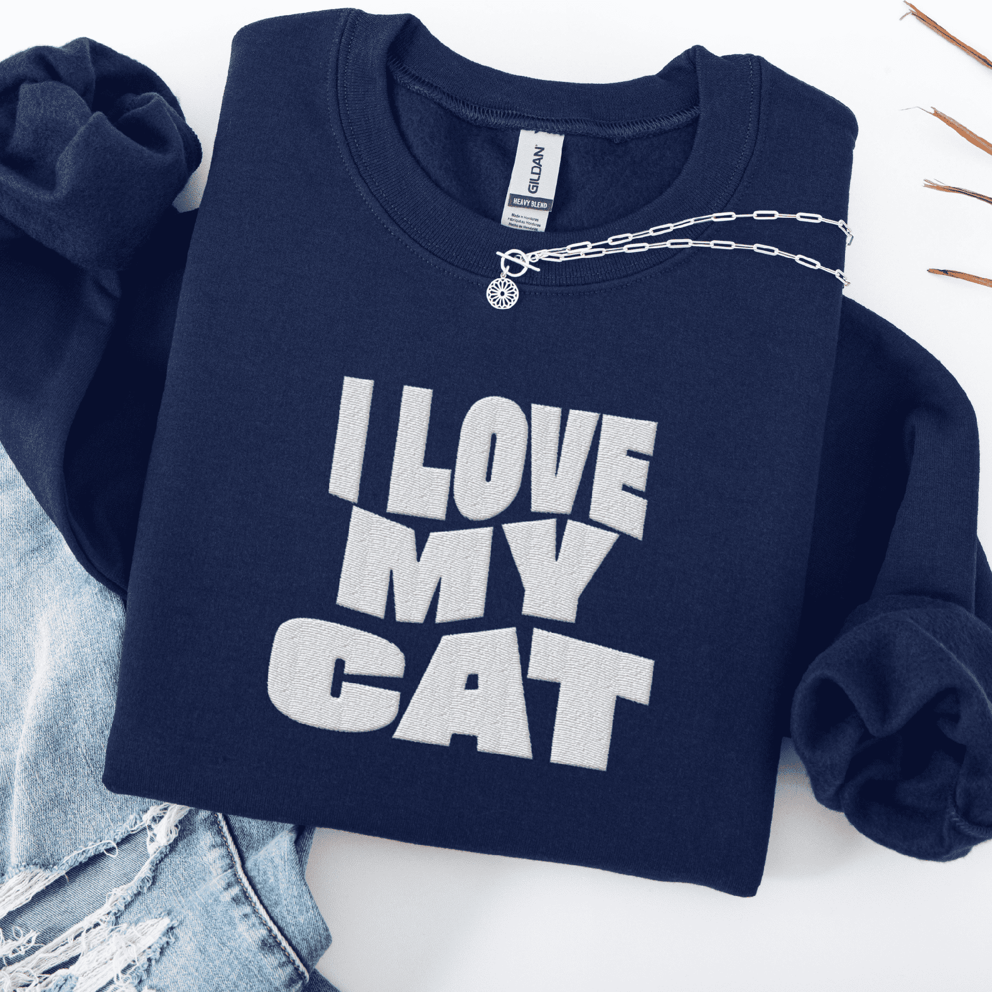 Navy embroidered cat sweatshirt with the phrase “I Love My Cat” shown folded flat