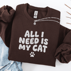 Dark Chocolate embroidered cat sweatshirt with the phrase “All I Need Is My Cat” shown folded flat