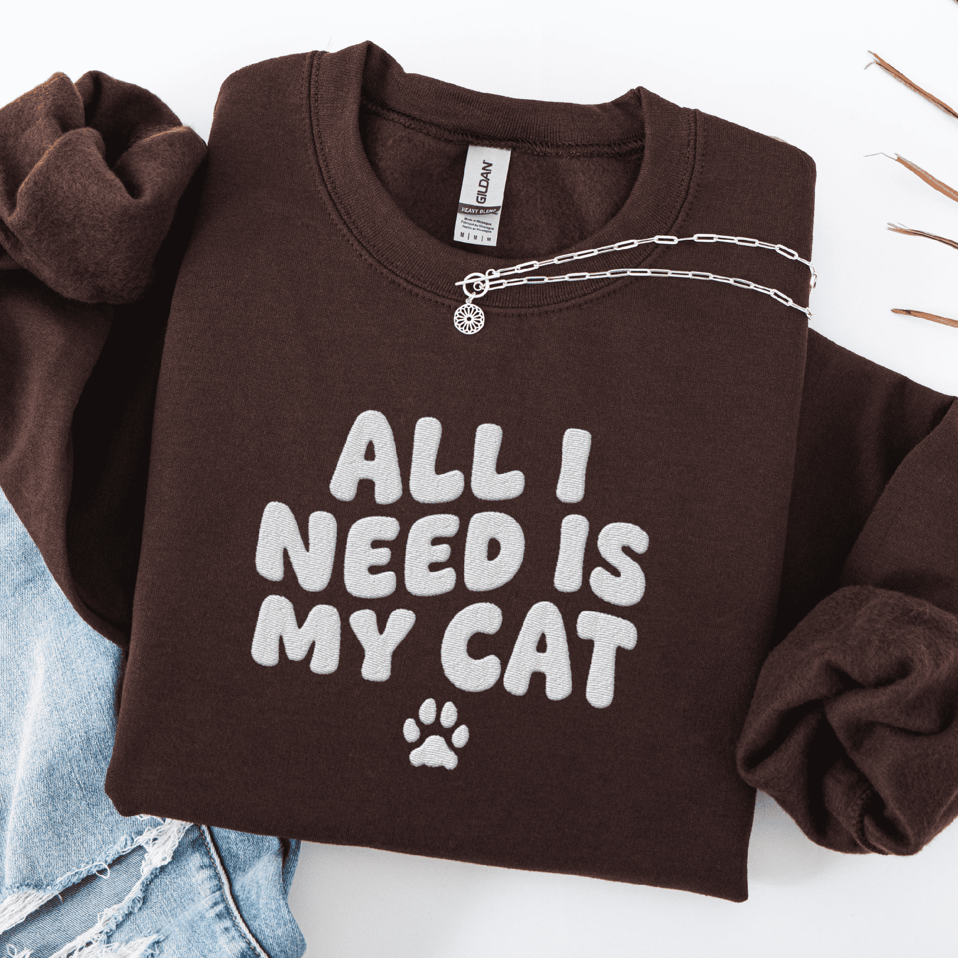 Dark Chocolate embroidered cat sweatshirt with the phrase “All I Need Is My Cat” shown folded flat