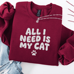 Maroon embroidered cat sweatshirt with the phrase “All I Need Is My Cat” shown folded flat