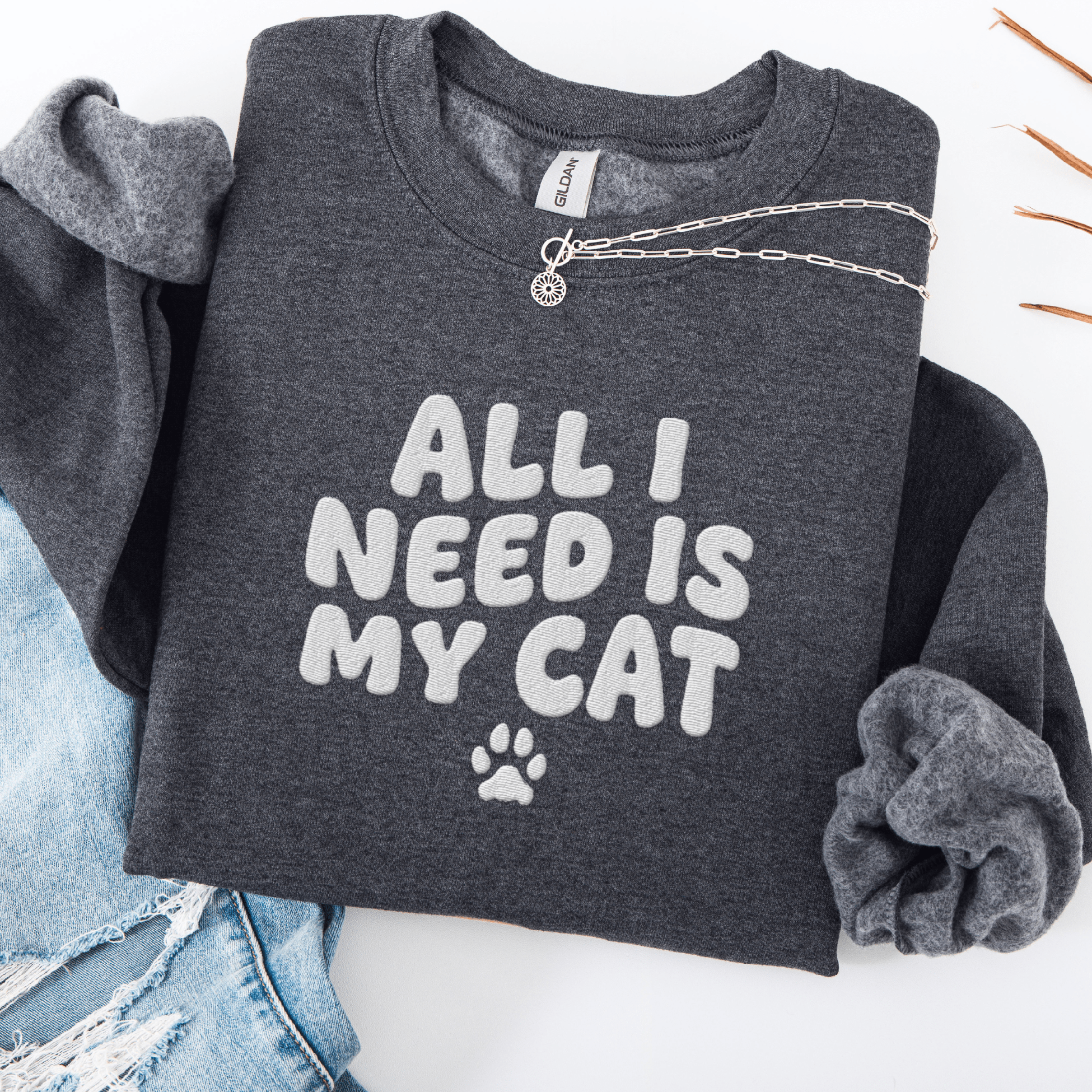 Dark Heather embroidered cat sweatshirt with the phrase “All I Need Is My Cat” shown folded flat