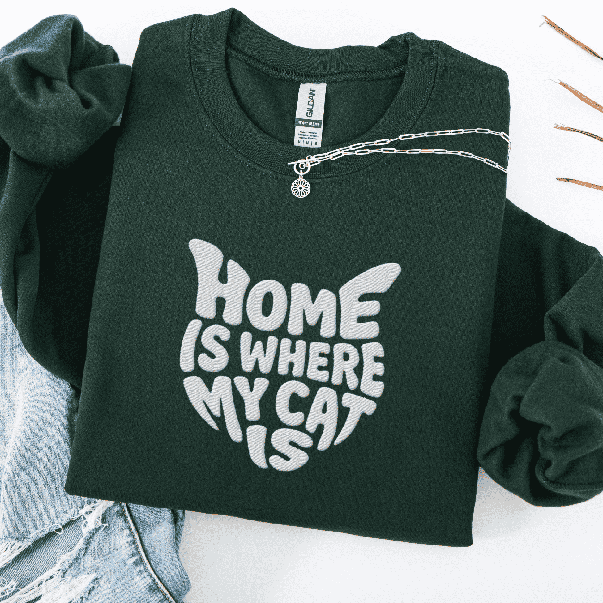 Forest Green embroidered cat sweatshirt with the phrase “Home Is Where My Cat Is” shown folded flat