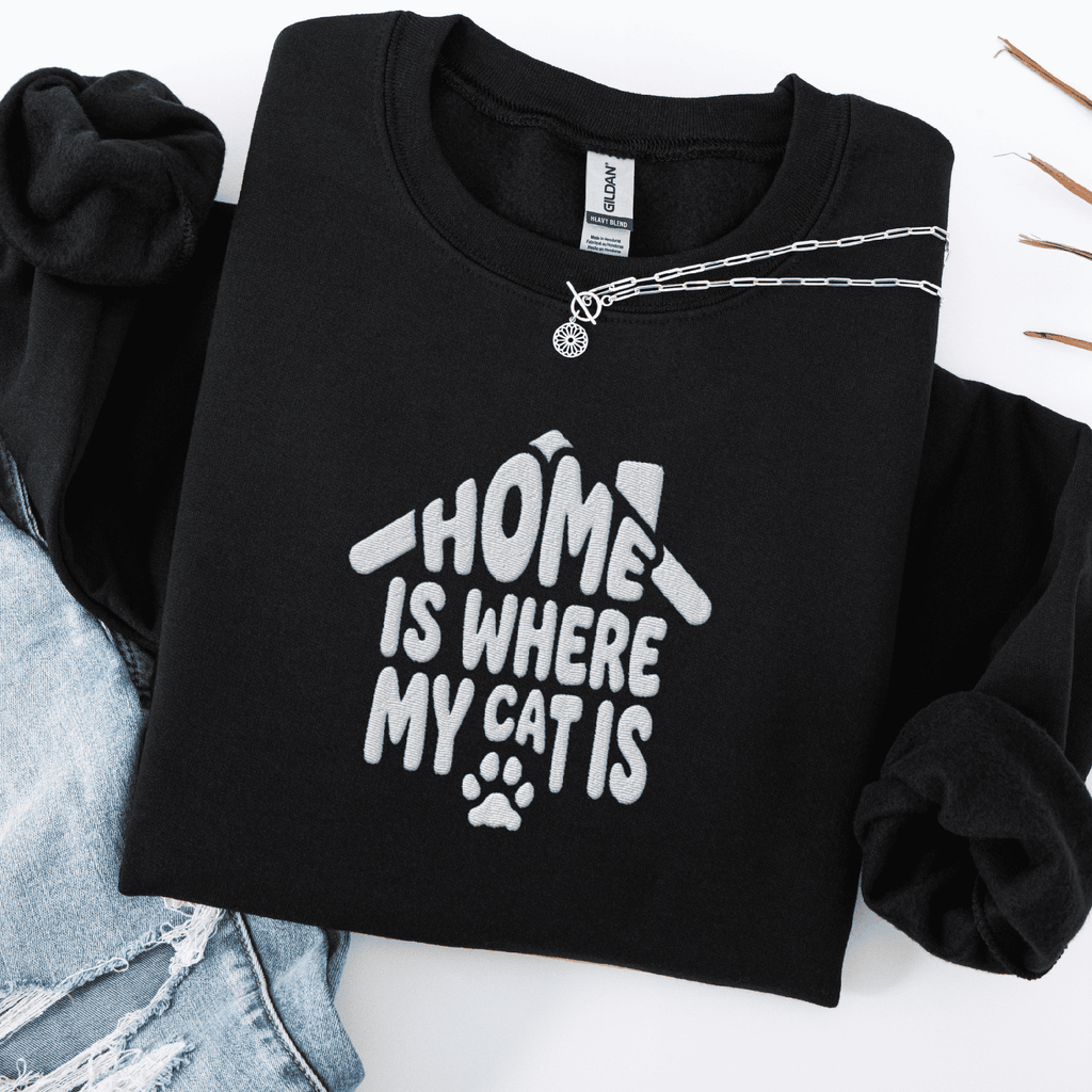 Black embroidered cat sweatshirt with the phrase “Home Is Where My Cats Are” shown folded flat