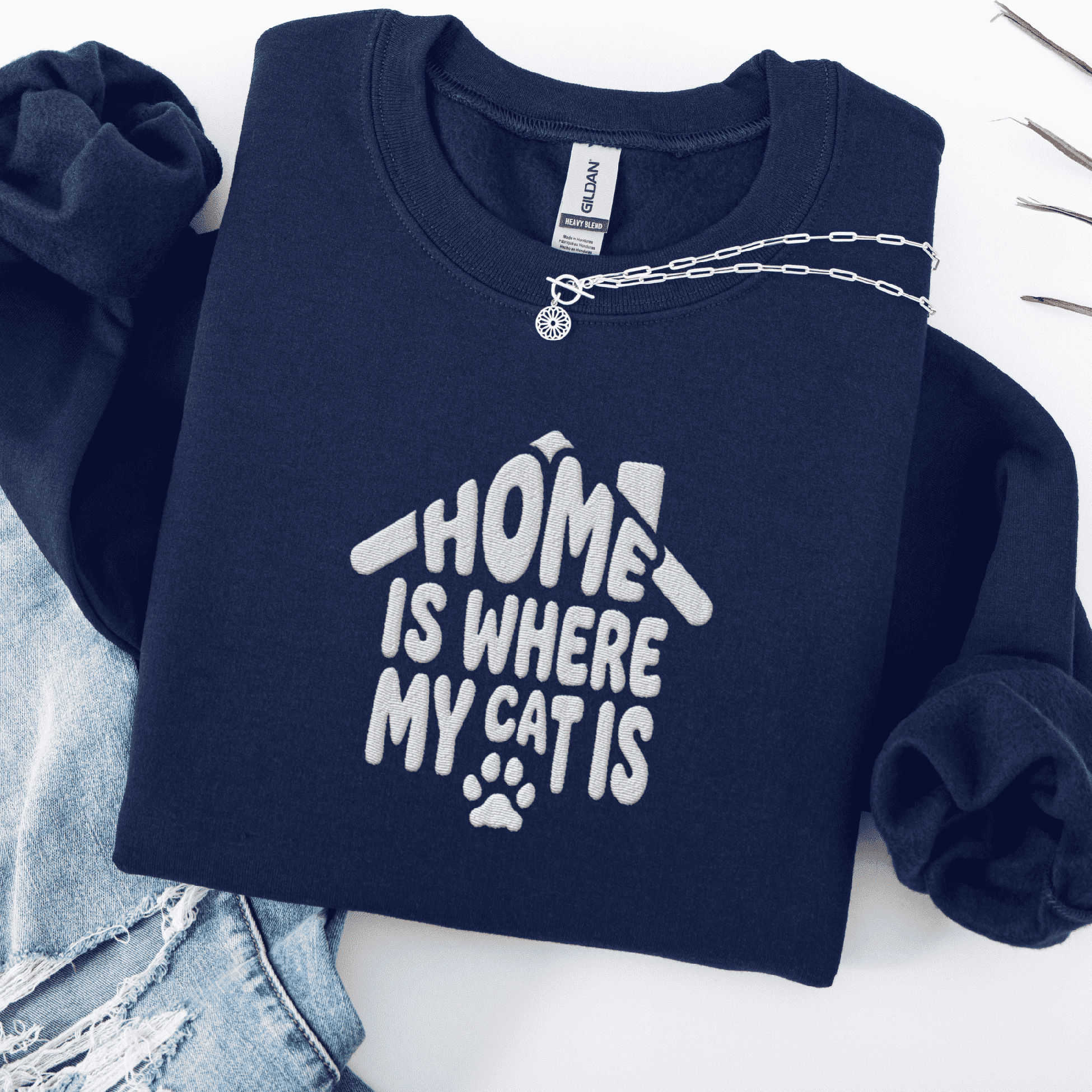 Navy embroidered cat sweatshirt with the phrase “Home Is Where My Cats Are” shown folded flat