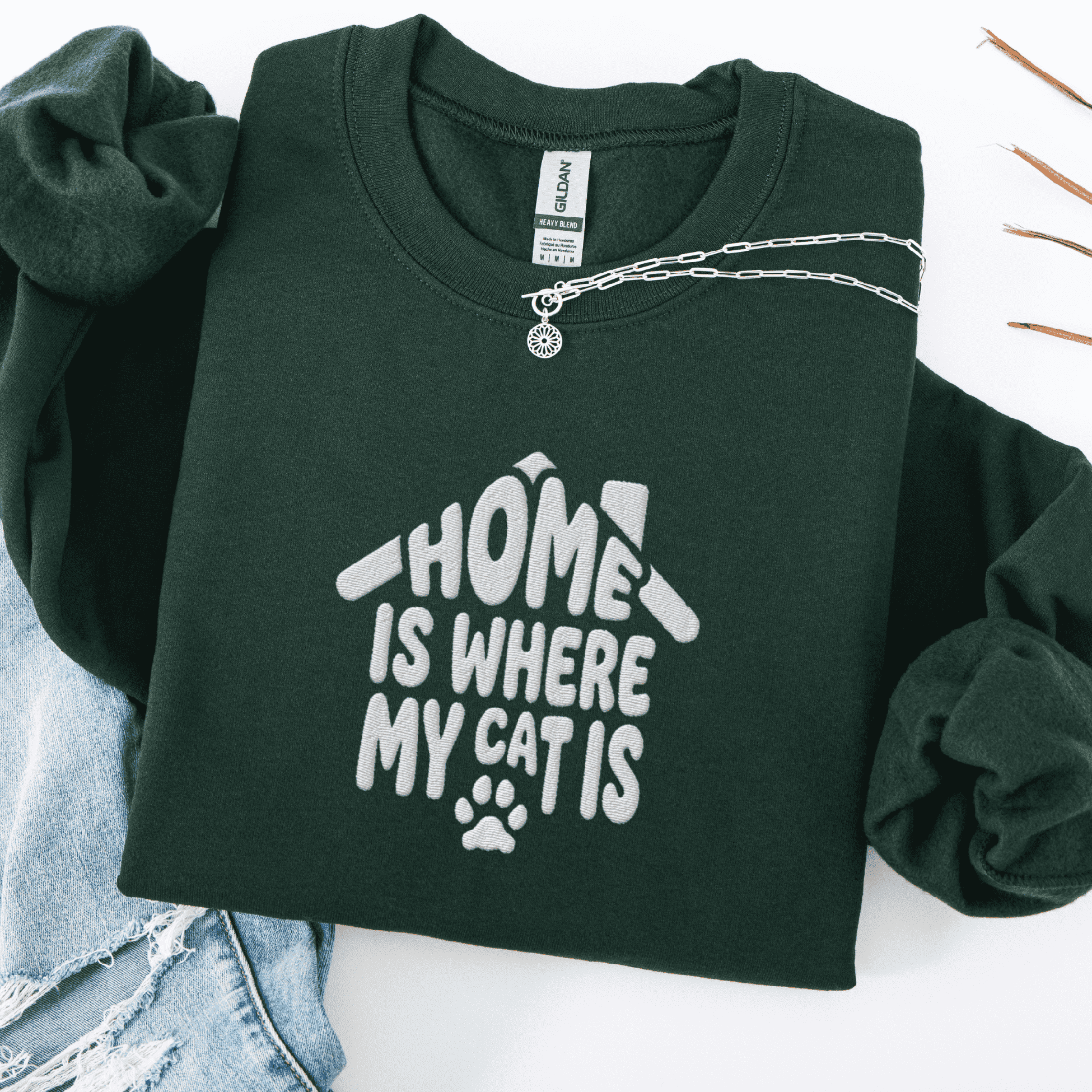 Forest Green embroidered cat sweatshirt with the phrase “Home Is Where My Cats Are” shown folded flat