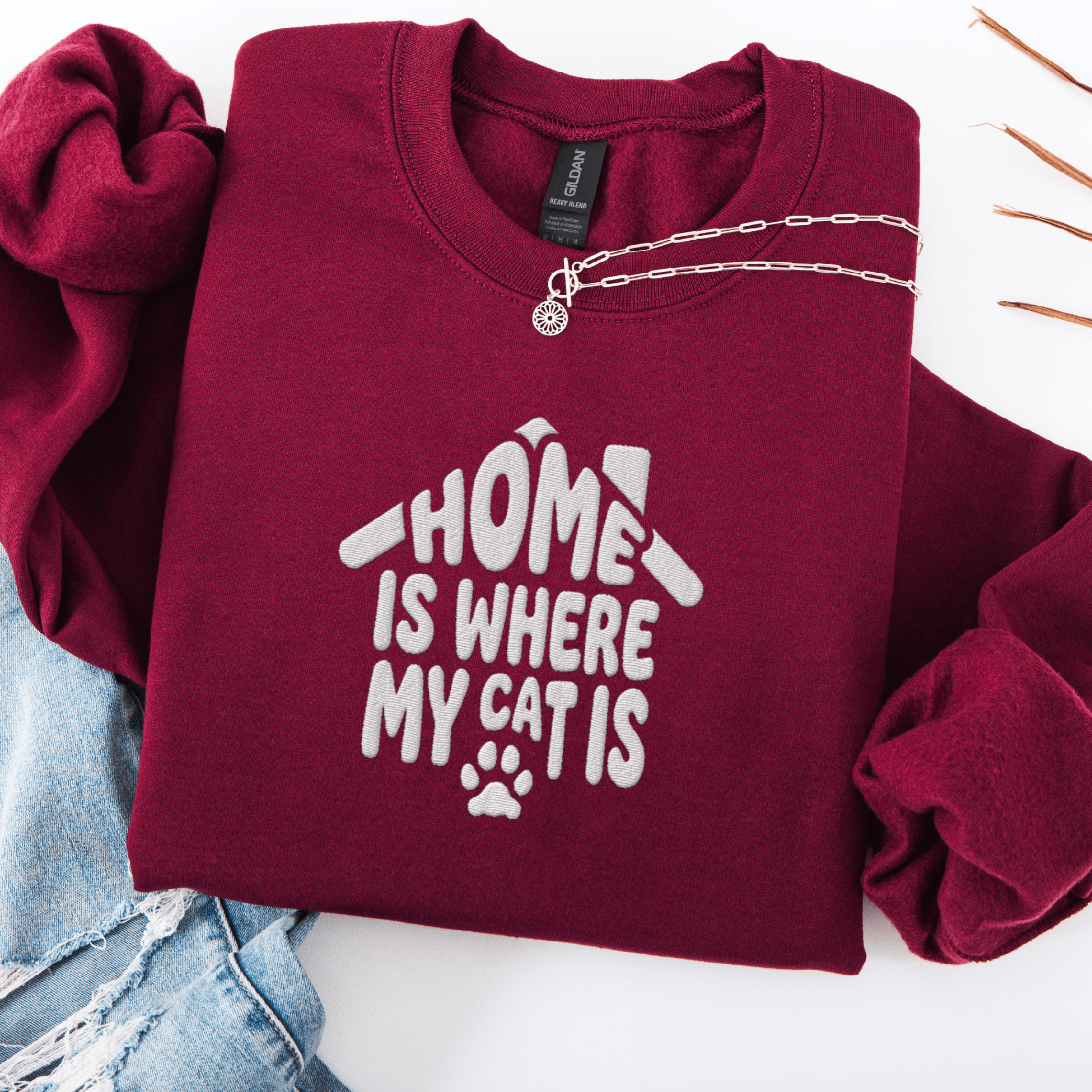 Maroon embroidered cat sweatshirt with the phrase “Home Is Where My Cats Are” shown folded flat