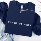Navy embroidered cat sweatshirt with the phrase “queen of cats” shown folded flat