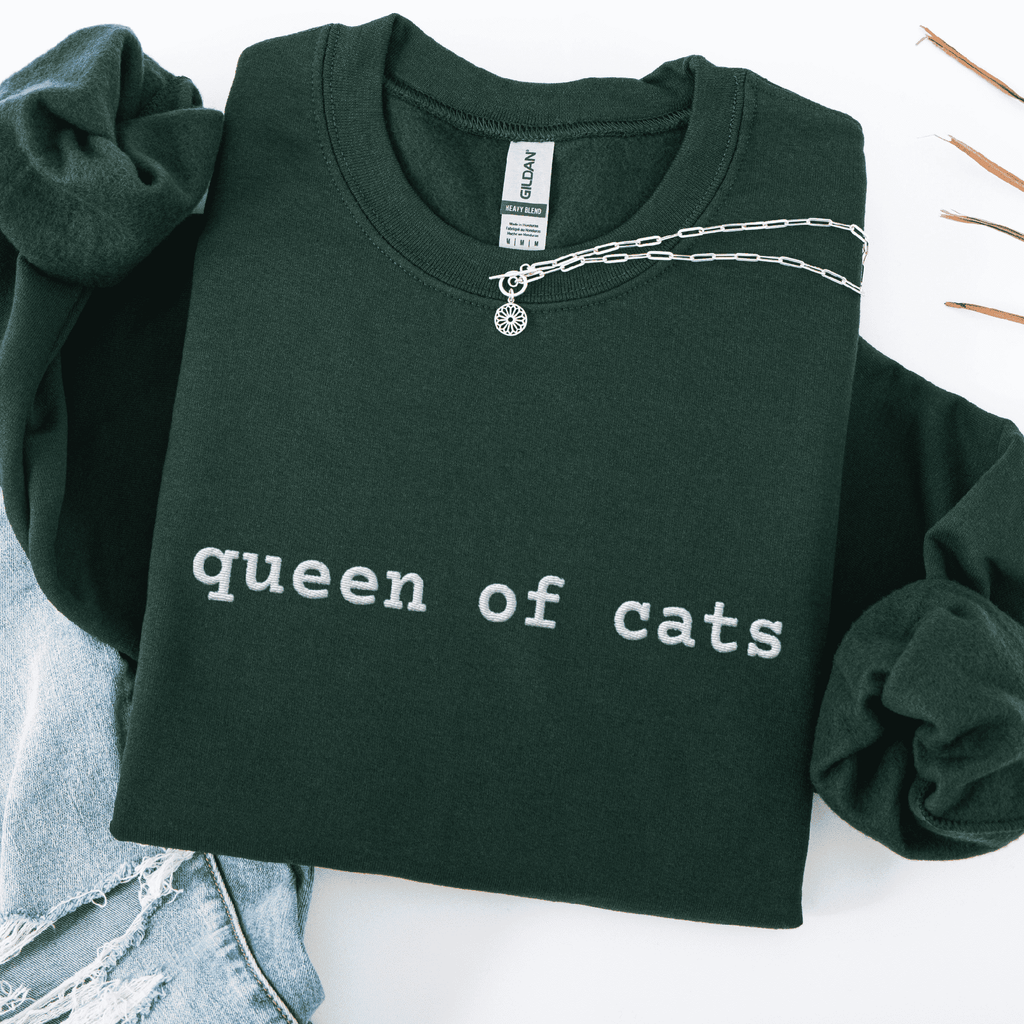 Forest Green embroidered cat sweatshirt with the phrase “queen of cats” shown folded flat