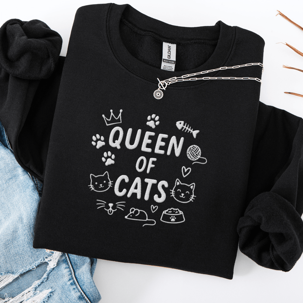 Black embroidered cat sweatshirt with “Queen of Cats” text and cat-themed doodle icons shown folded flat